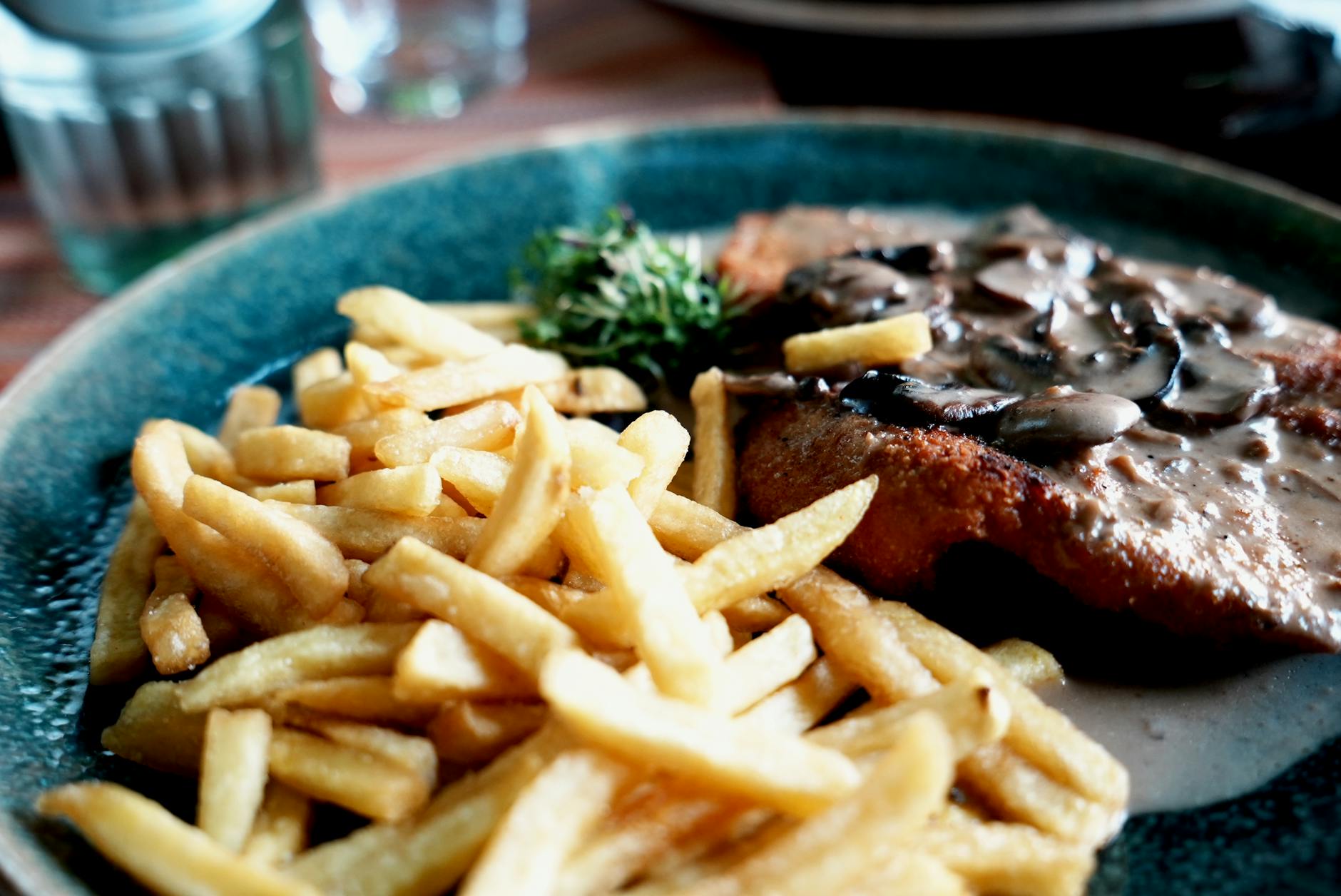 Classic Wiener schnitzel with lemon and potatoes on restaurant plate