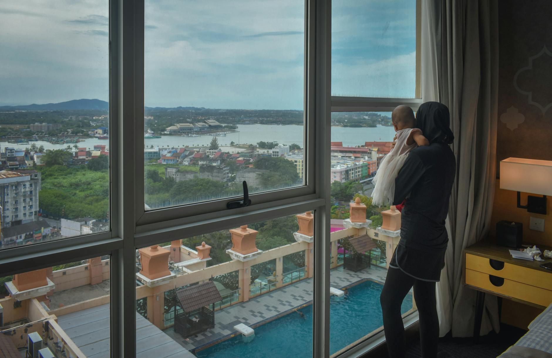 Munich family hotels guide showing kids in hotel pool and family room with city skyline backdrop