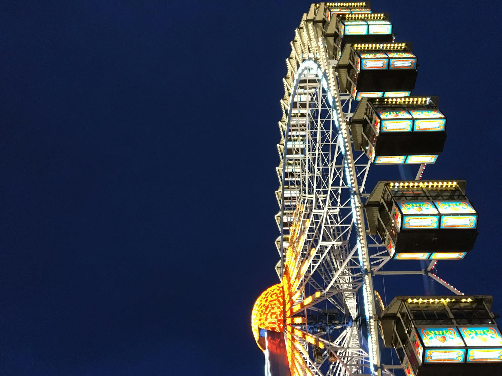 Riesenrad Ferris wheel and Olympia Looping roller coaster rides at Oktoberfest at dusk