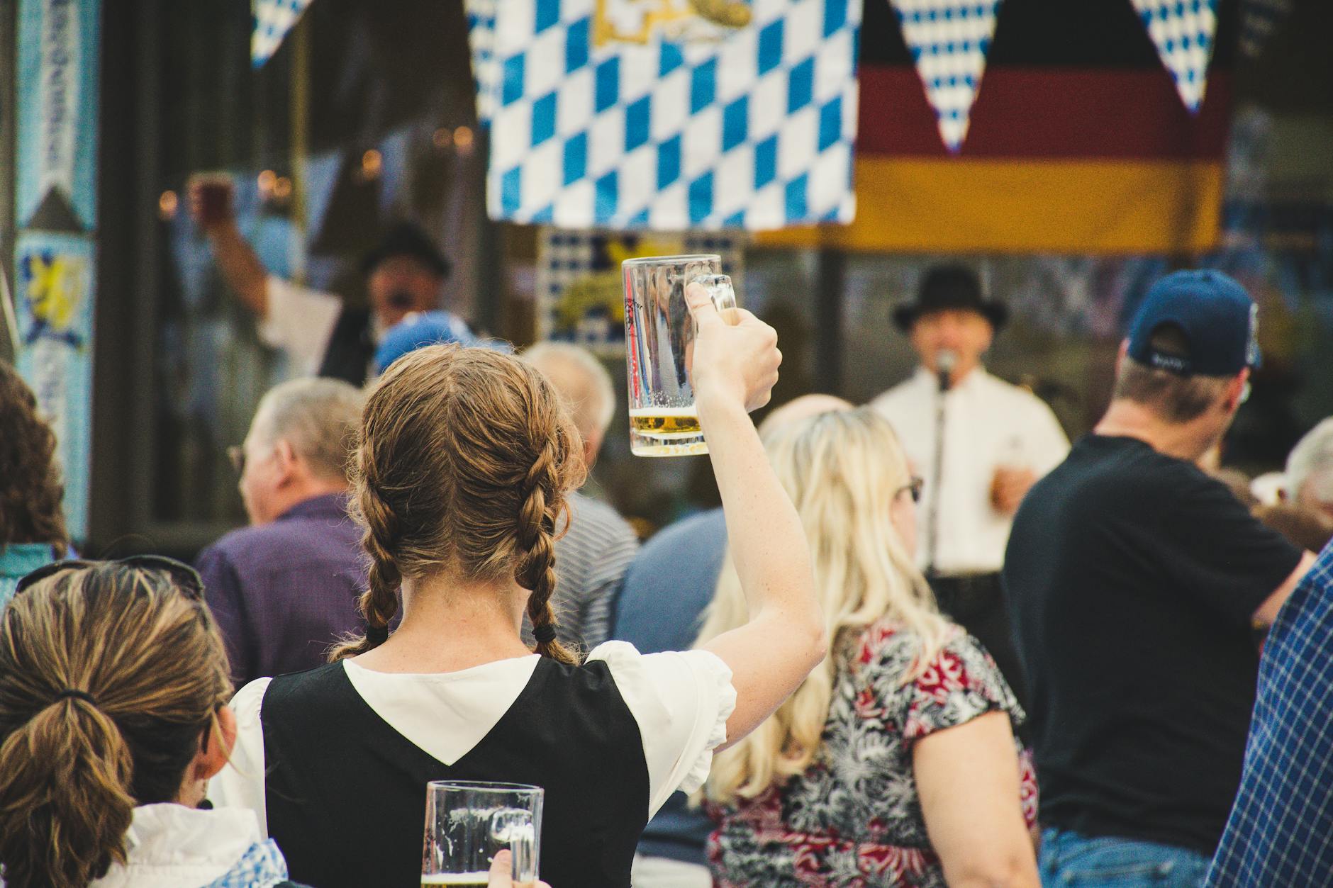 Oktoberfest first time tips: crowded Augustiner-Festhalle beer tent at midday with raised Maß steins