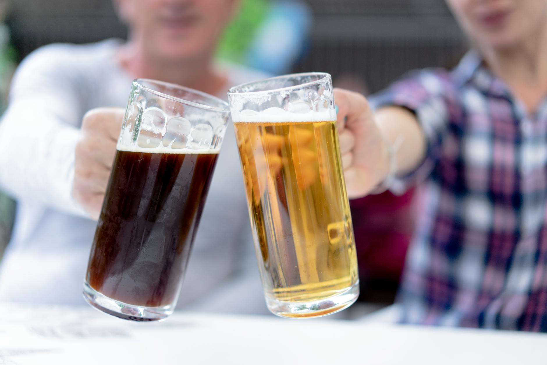 Wiesn revellers raising Maß steins for a Prost toast at sunset