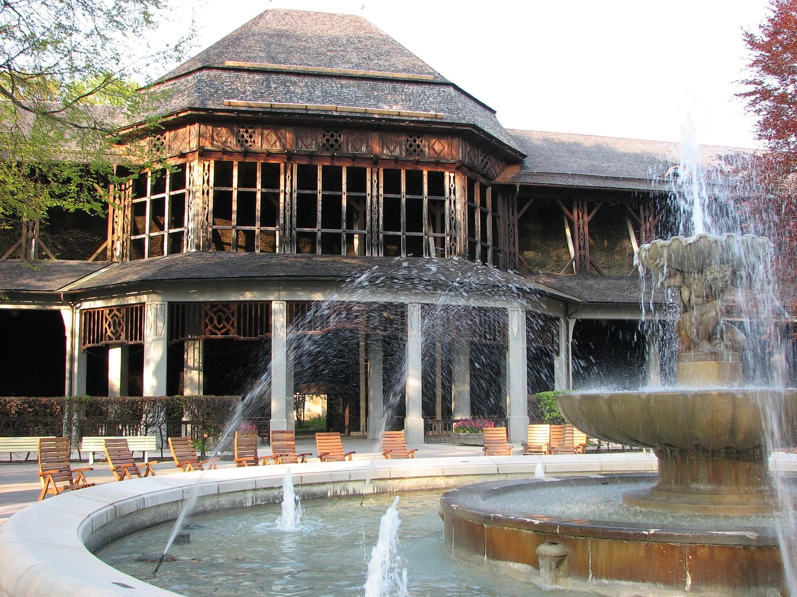 Bad Tölz, Bad Wiessee and Bavaria's Spa Towns 2 A timber pavilion with a fountain and loungers in front of it in a park