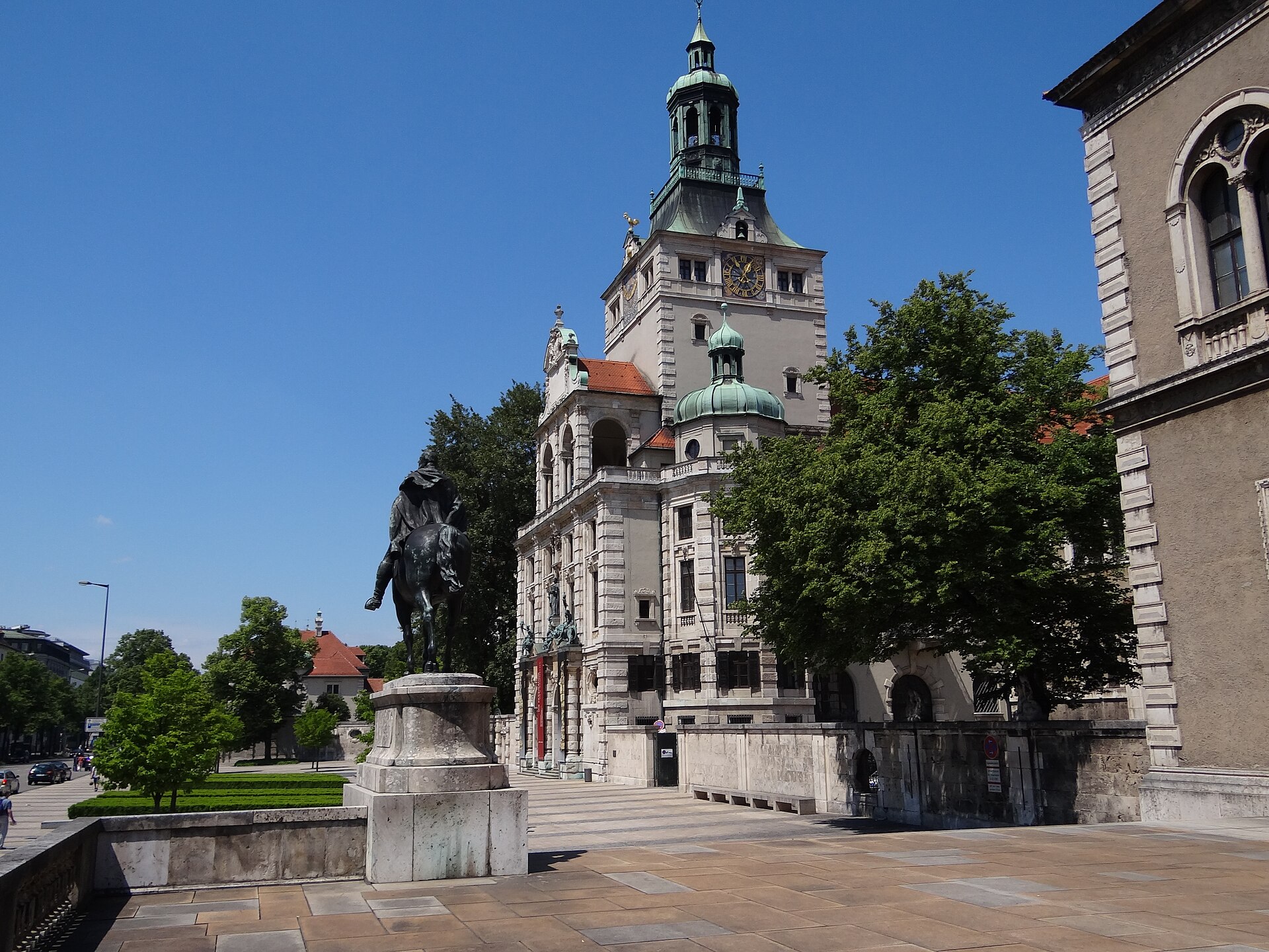 Best History Museums in Munich: From Royals to WWII 3 The Bavarian National Museum in Munich with its clock tower, green cupolas and an equestrian statue in the forecourt.