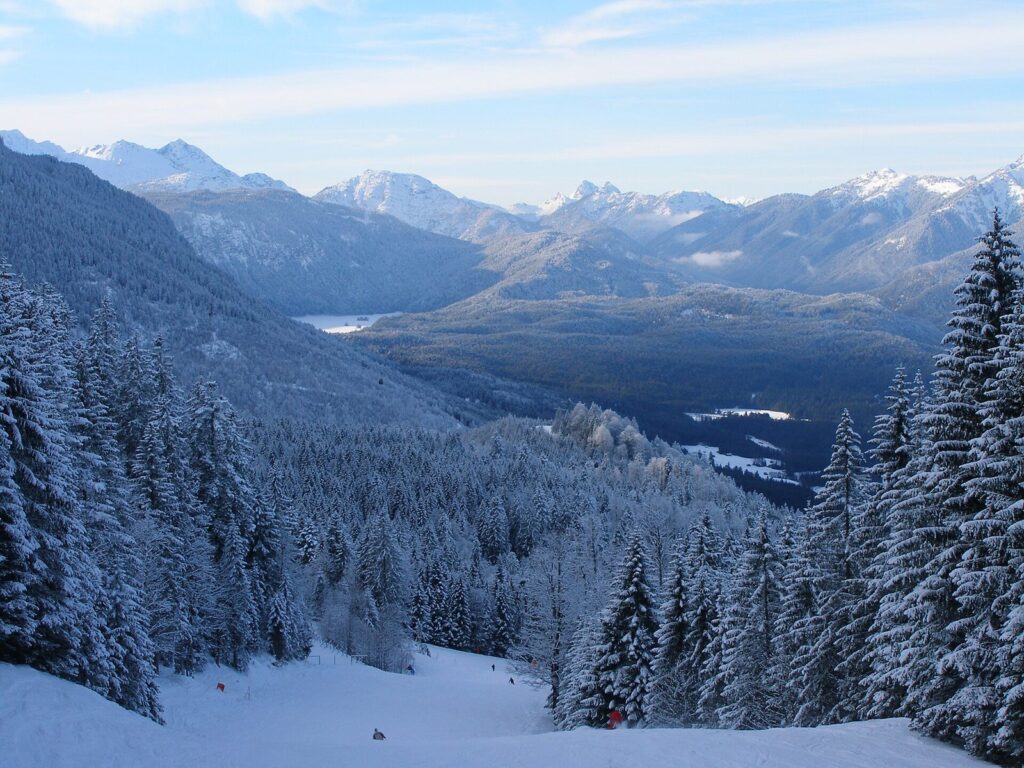 Skiing Near Munich: Best Resorts for a Day on the Slopes 1 A snowy piste between frosted fir trees on the Kandahar run above Garmisch-Partenkirchen, with mountains beyond