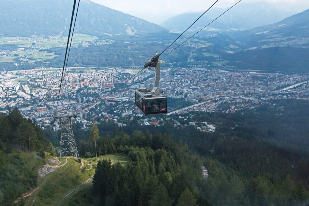 A Nordkettenbahn cable car cabin above the rooftops of Innsbruck and the Inn valley