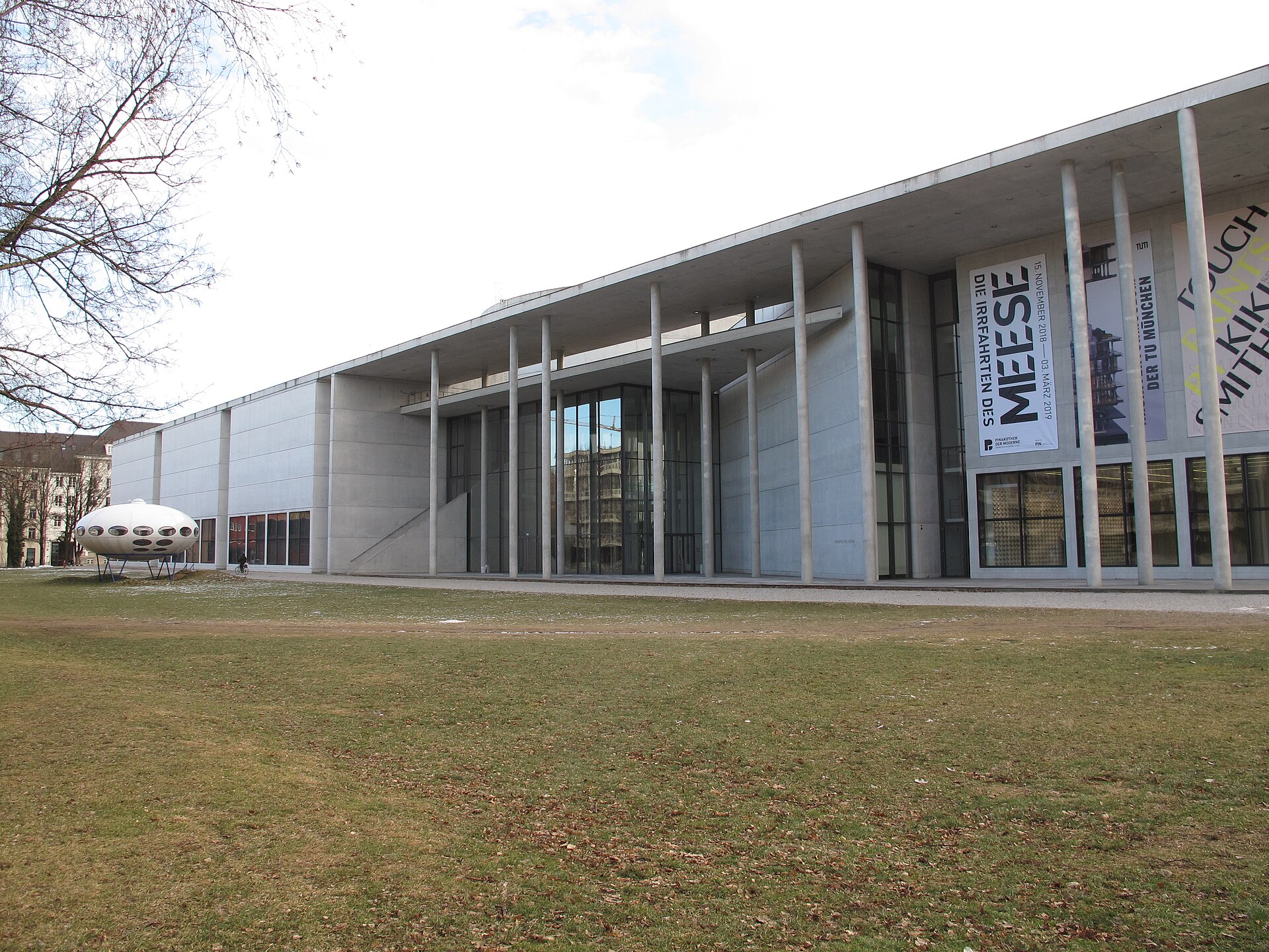 Munich Museum Pass and Discount Tickets: Complete 2026 Guide 1 The Pinakothek der Moderne in Munich stretches beside a lawn, its tall columns framing a glass entrance.