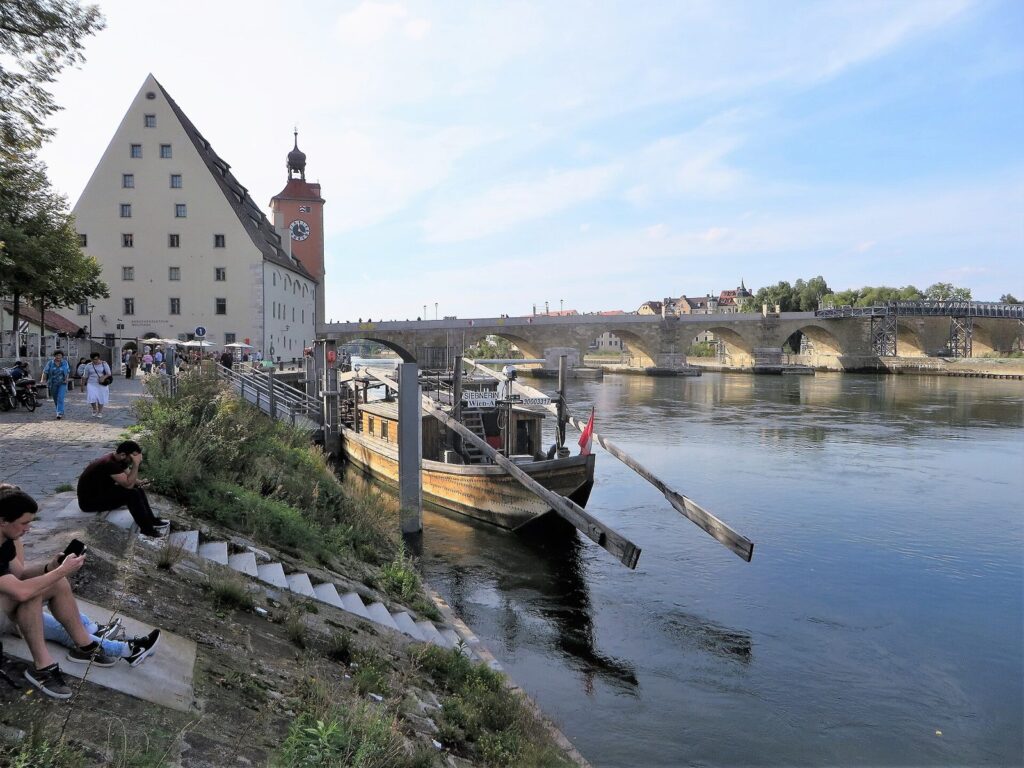 Munich to Prague: Train, Bus and Which to Take 1 The Salzstadel, the bridge tower and the Stone Bridge across the Danube in Regensburg, an old ship moored in front