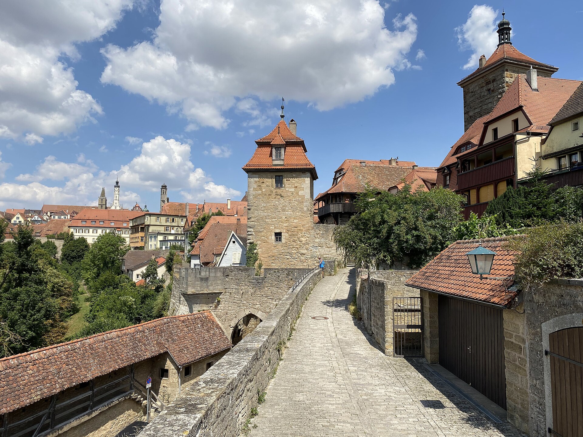 Rothenburg ob der Tauber from Munich: Complete Day Trip Guide 1 Stone towers and a roofed wall passage overlook a cobbled path and Rothenburg ob der Tauber’s red rooftops.