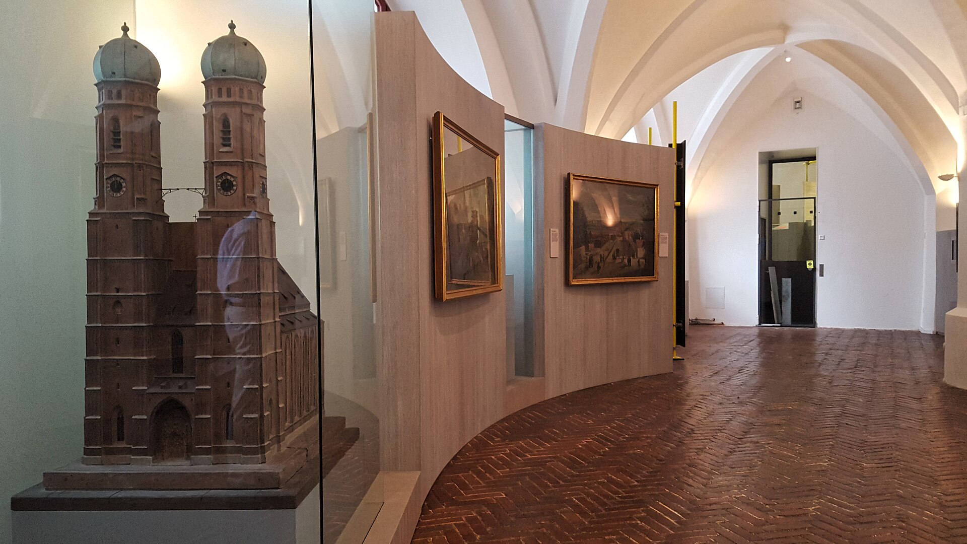 Best History Museums in Munich: From Royals to WWII 4 A twin-towered church model and framed paintings stand beneath white vaults inside the Munich City Museum.